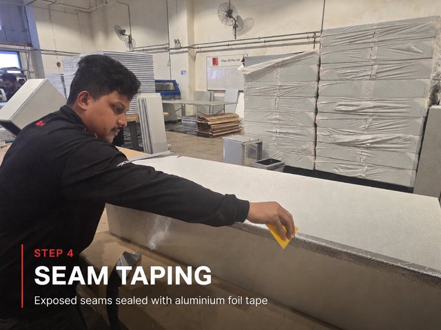 Step 4, seam taping: a fabricator pressing aluminium foil tape along the external corner seam of a formed duct section.