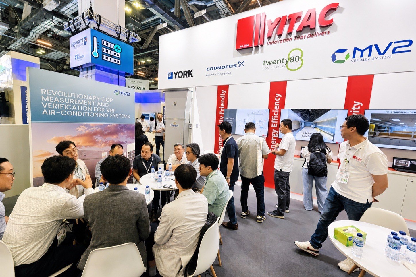 The YITAC stand at BEX Asia 2025: visitors seated in discussion with YITAC staff, under signage carrying the YORK, Grundfos, Twenty80 and MV2 marks.